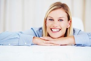 Closeup of cheerful young female executive smiling while looking at you